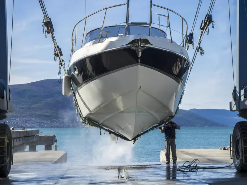 Power washing barnacles on a yacht in dry dock