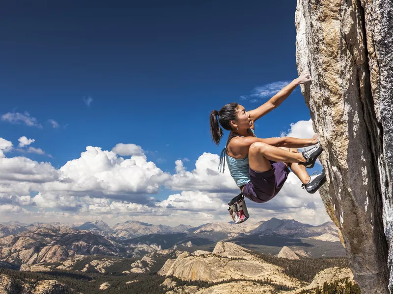 Rock climber climbing a challenging cliff