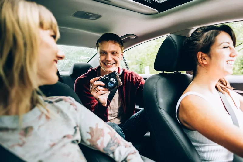 Friends enjoying ride in car in rural countryside