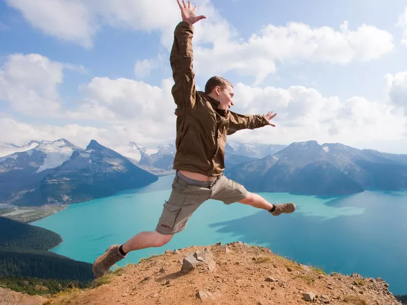 Hiker jumping for joy at a panorama ridge