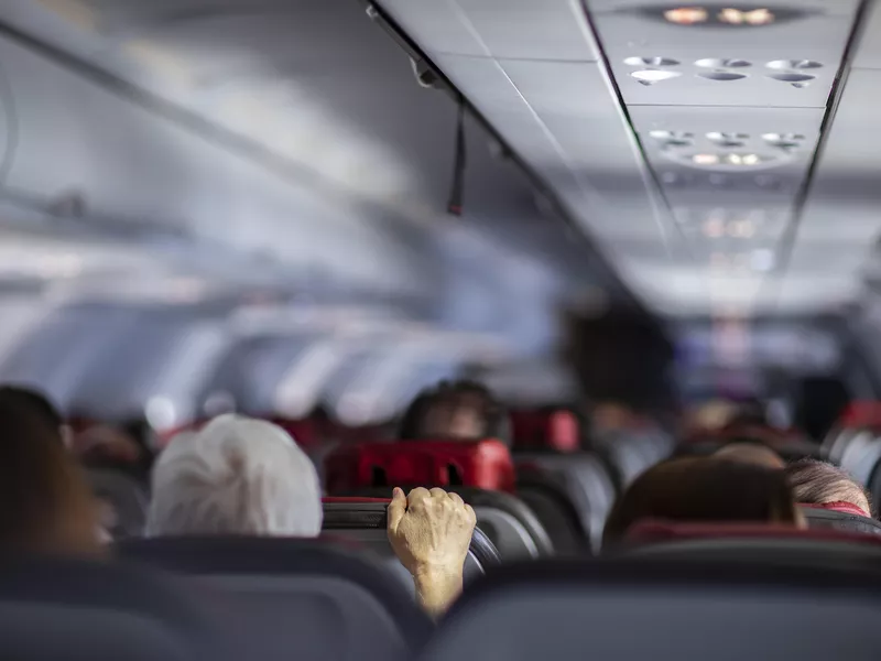 Woman afraid of flying holding an airplane seat