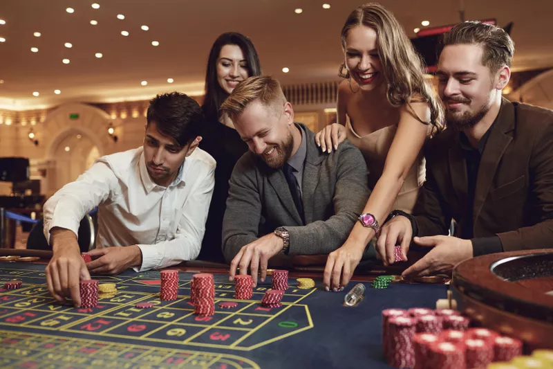 Happy friends playing roulette in a casino