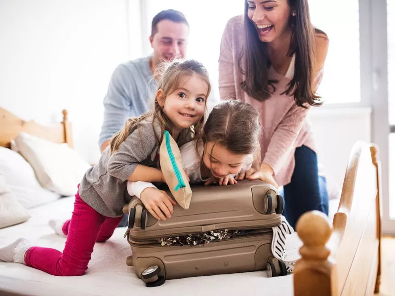 Young family with two children packing for holiday.