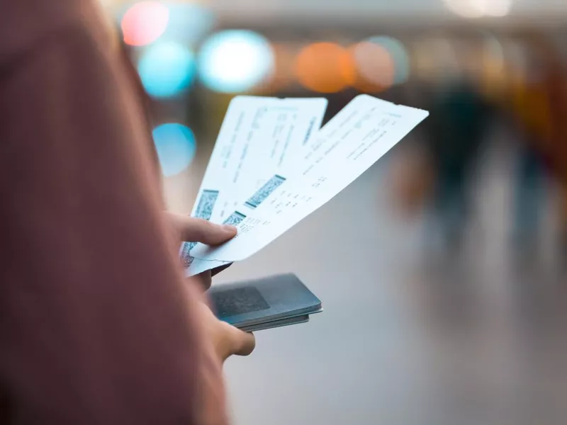 Girl holds tickets, boarding passes for a flight