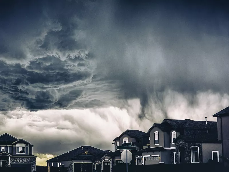 Dramatic storm clouds over residential neighborhood.