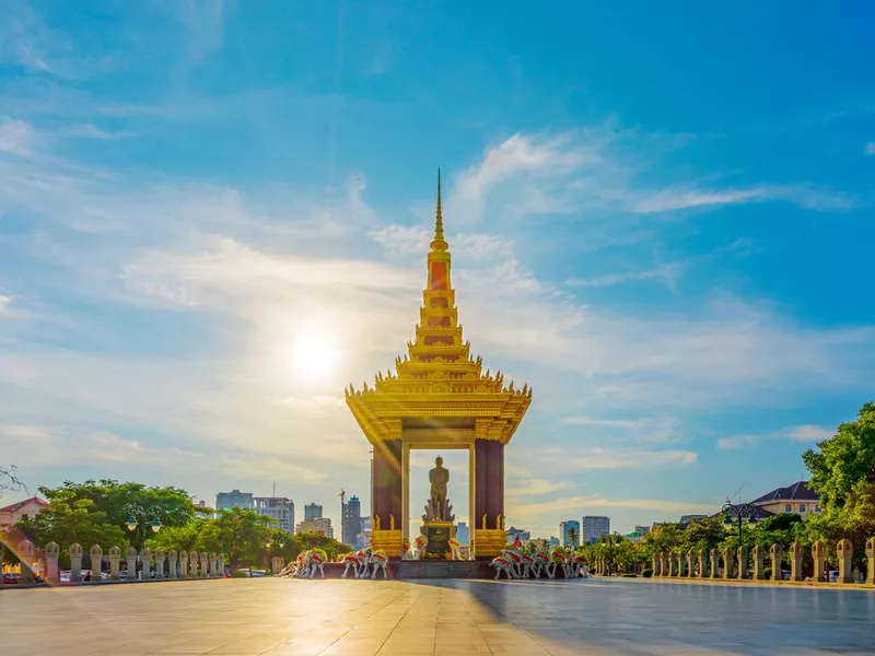 A Statue of King Father Norodom Sihanouk with blue and yellow sky in evening sunset background at central Phnom Penh, Capital of Cambodia.