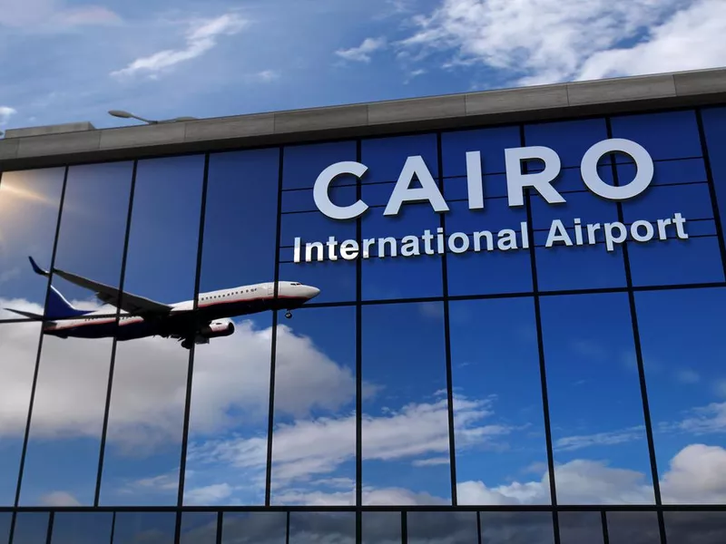 Airplane landing at Cairo mirrored in terminal