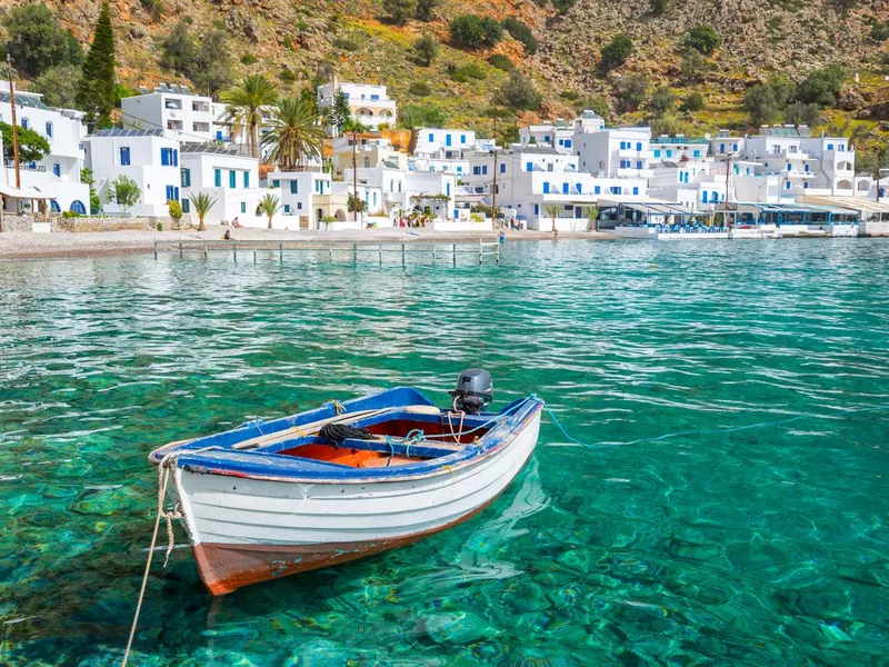 Fishing boat and the scenic village of Loutro in Crete, Greece