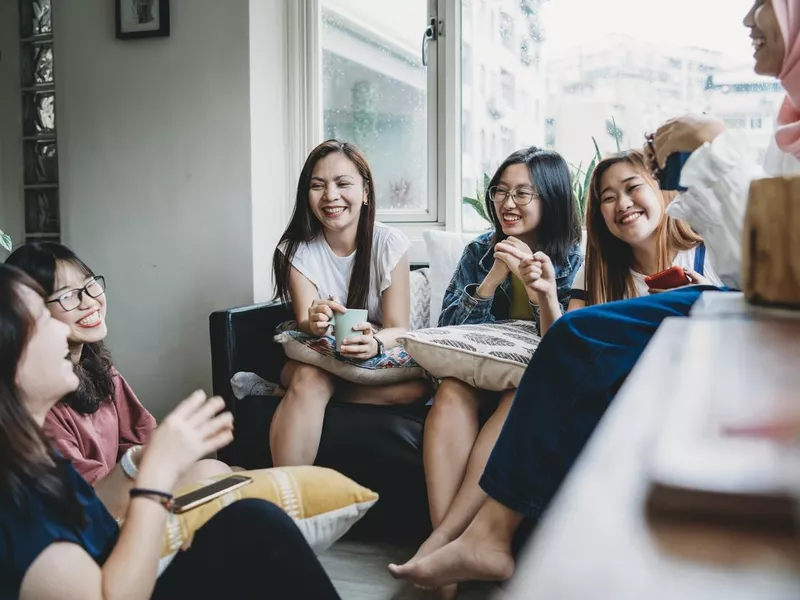 Friends talking and drinking coffee at home