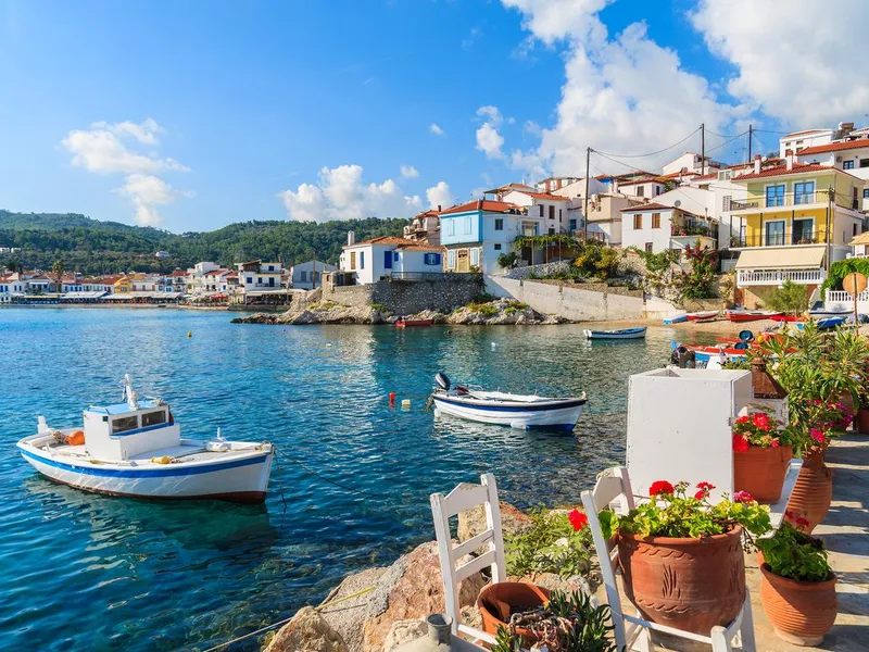 Flowers on shore with fishing boats in Kokkari port, Samos island, Greece