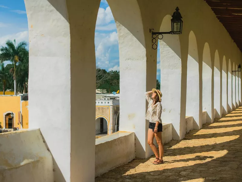 Woman walking among columns in Izamal town in Mexico