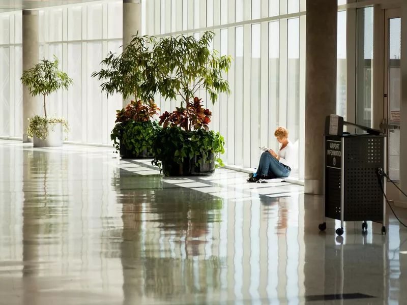 Woman reading a book in George Bush Intercontinental airport, Houston, Texas, USA.