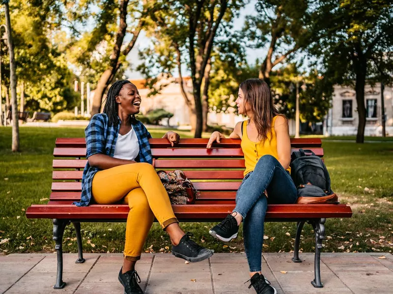 Friends talking on bench