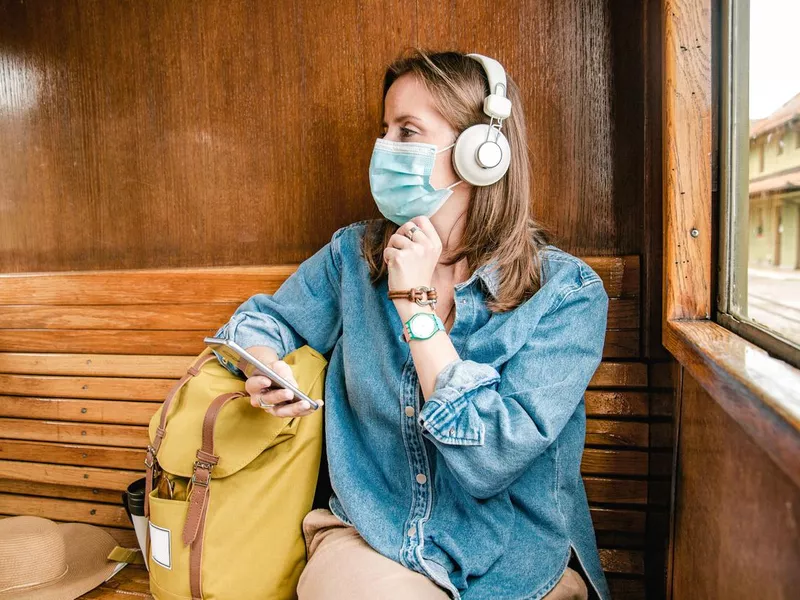 Woman with a mask traveling by train