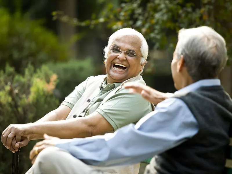 Two senior men discussing on park bench