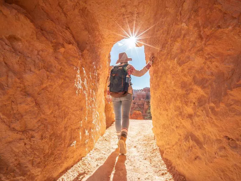 Young woman travels Bryce Canyon national park in Utah, United States, people travel explore nature. Girl hiking in red rock formations