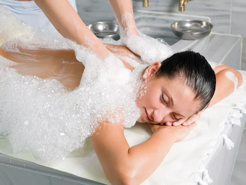 A relaxed woman receiving a Turkish bath