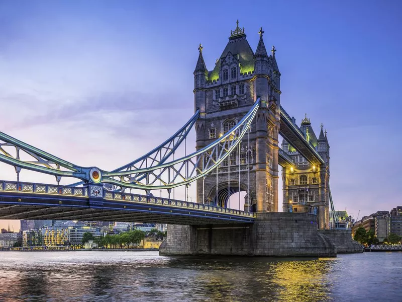 London Tower Bridge illuminated at sunset over River Thames panorama