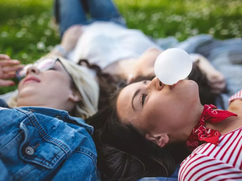 Friends chewing gum in a park