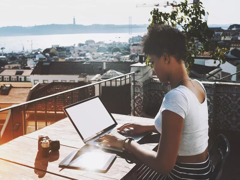 Girl with laptop on balcony in Madeira, Portugal