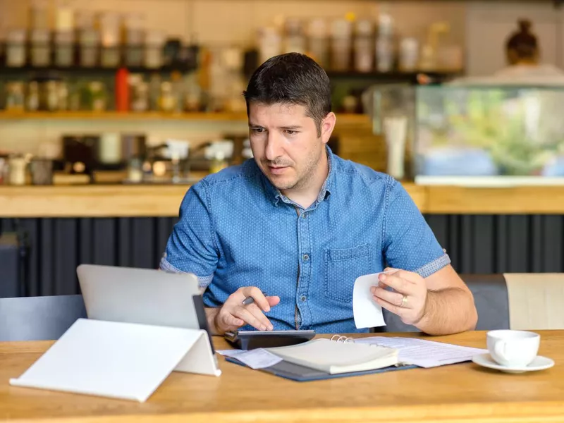 Small business owner calculating finances in Timisoara