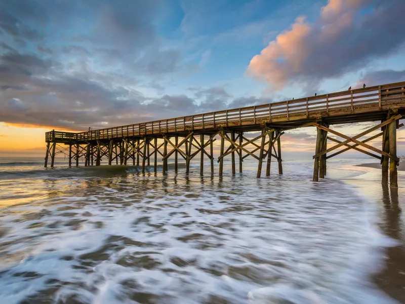 Waves in the Atlantic Ocean and the pier at sunrise, in Isle of Palms, South Carolina