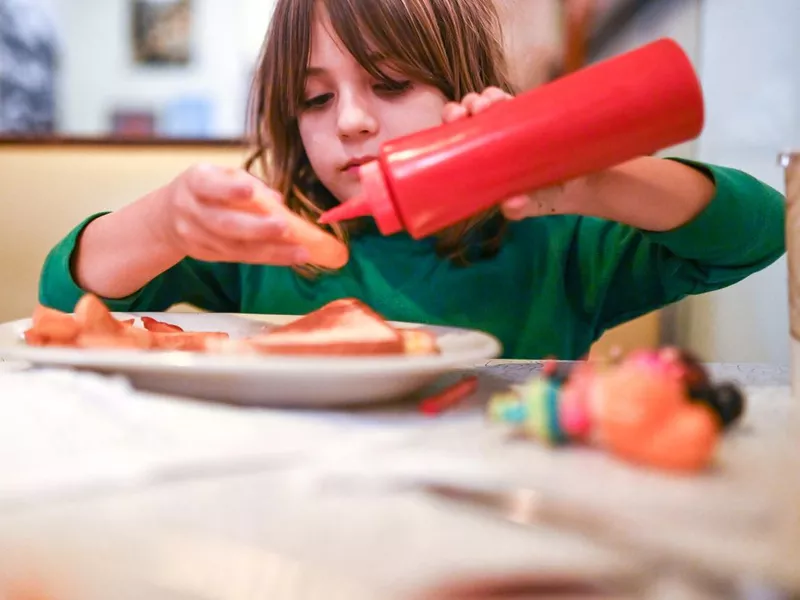 Kid eating ketchup