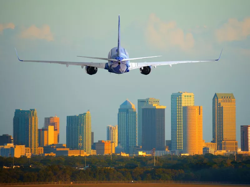 Passenger jet airliner plane arriving or departing Tampa International Airport in Florida at sunset or sunrise