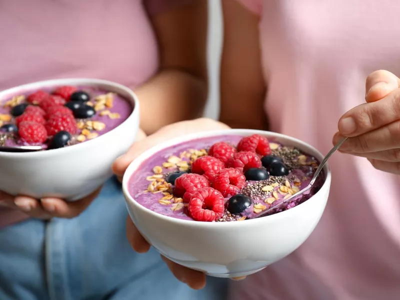 Women with tasty natural acai smoothie, closeup