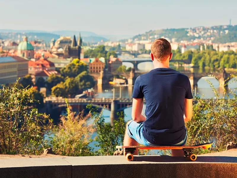 Skateboarder overlooking old town Prague