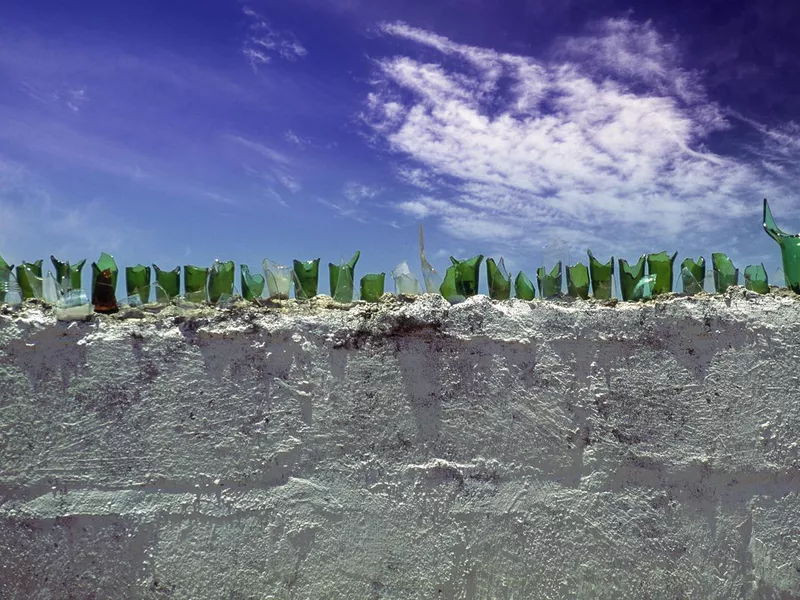 Broken glass bottles on wall for security in a dangerous town