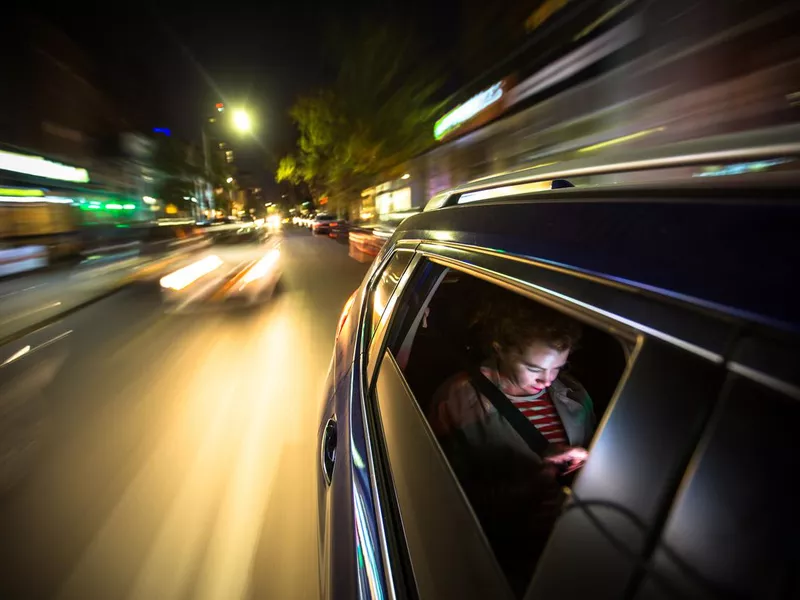 Young man riding as a passenger in a car