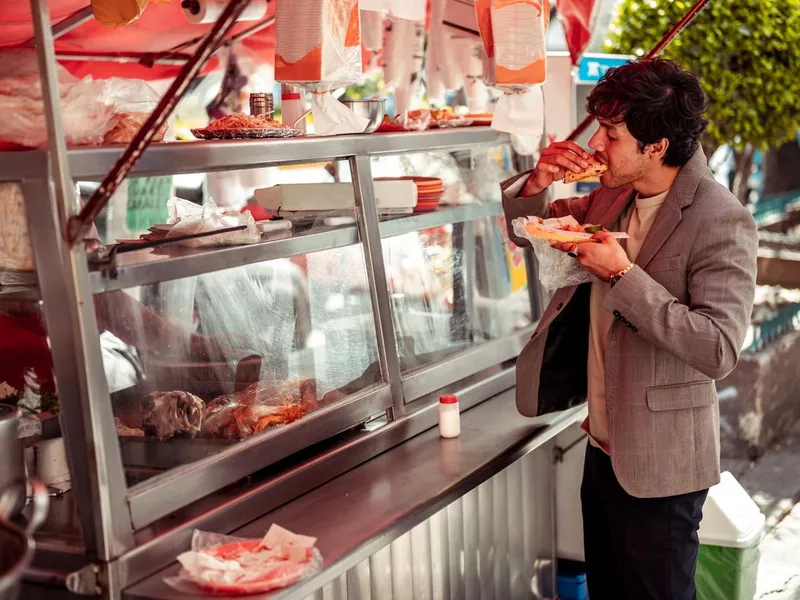 Young businessman garbing quick lunch