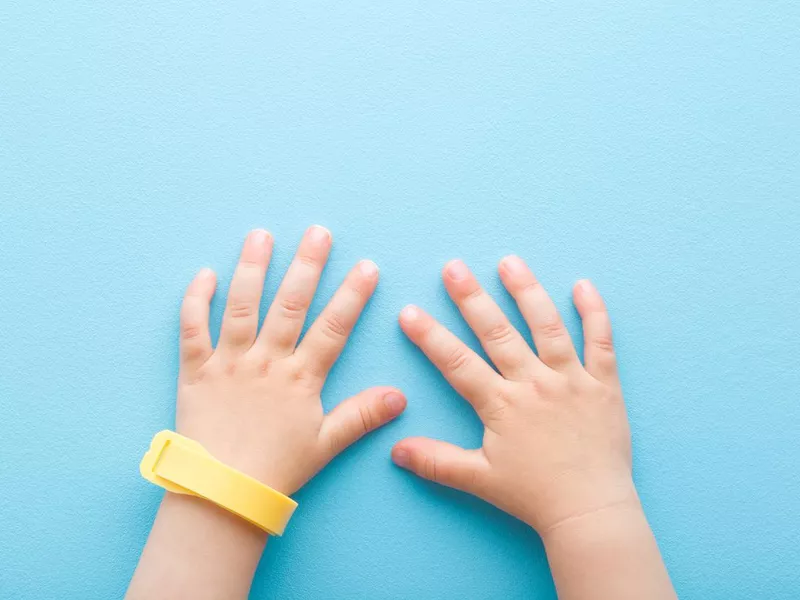 Yellow mosquito repellent band on baby wrist