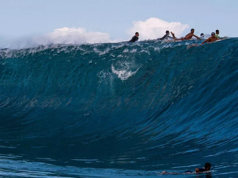 Surfers in Teahuppo