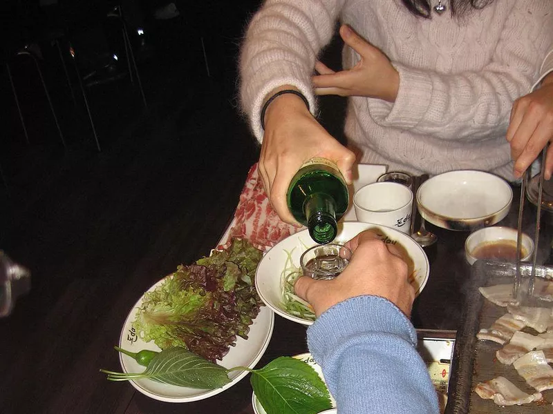 Pouring soju in Korea hand gesture