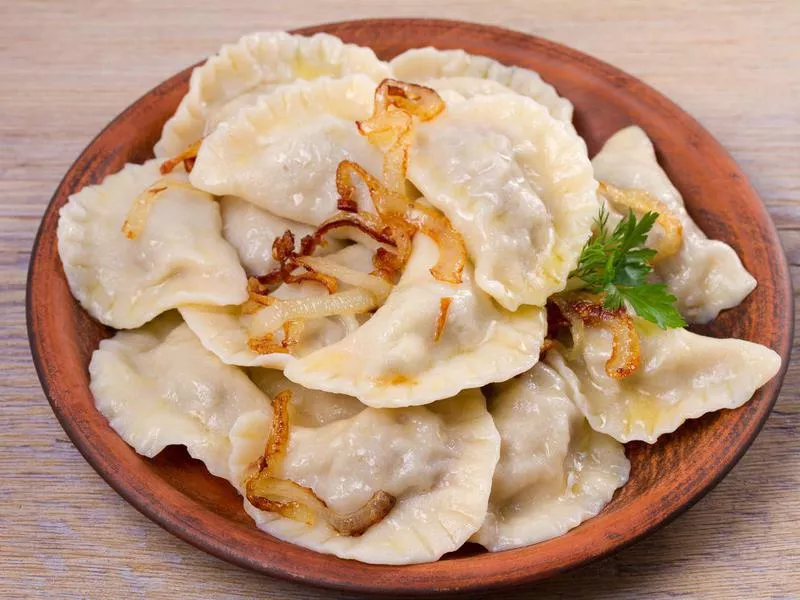 Dumplings, filled with beef meat and served with fried onion. Varenyky, vareniki, pierogi, pyrohy. Dumplings with filling