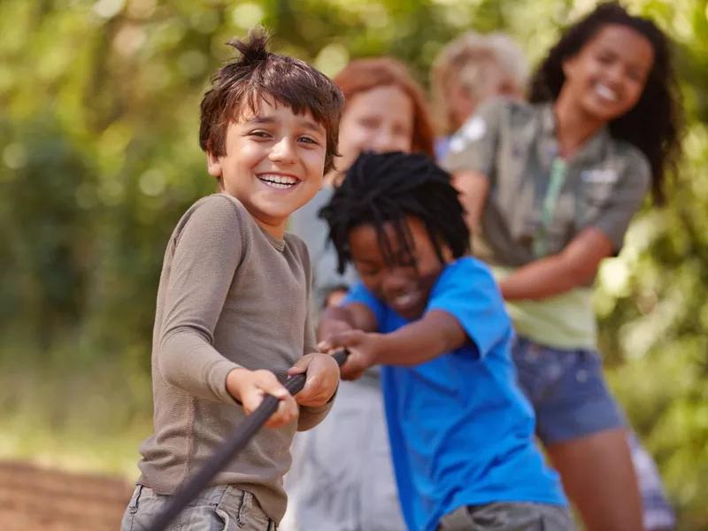 A group of kids in a tug-of-war in summer camp