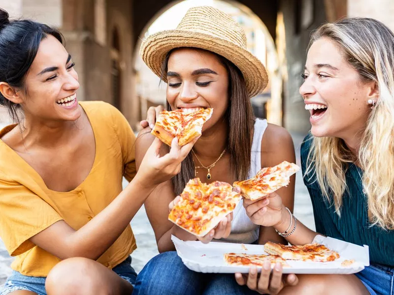 Friends eating pizza in Italy