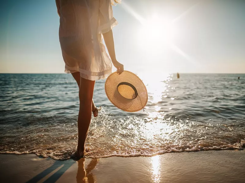 Woman's legs splashing water on the beach