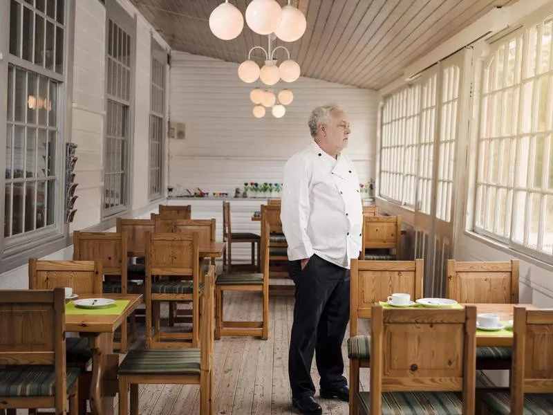 Restaurant owner standing in an empty restaurant.