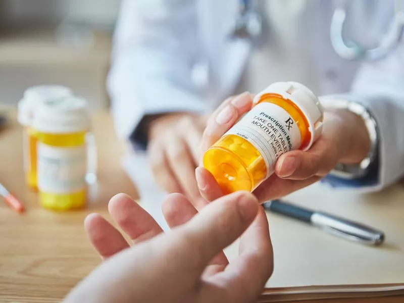 Doctor giving prescription medication to patient