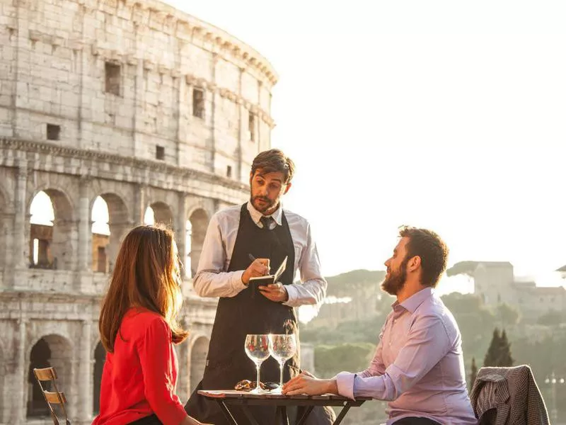 Tourists eating next to the Coliseum