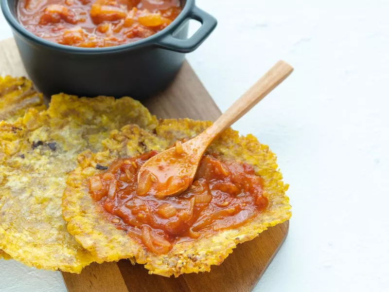 Pot with fried tomato accompanied by fried plantain, platano con hogao