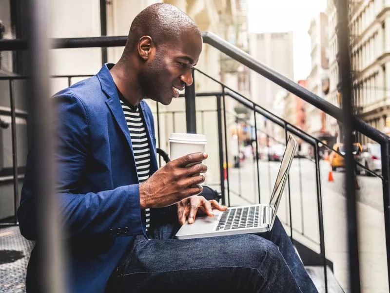 Man working on laptop outside in Soho New York