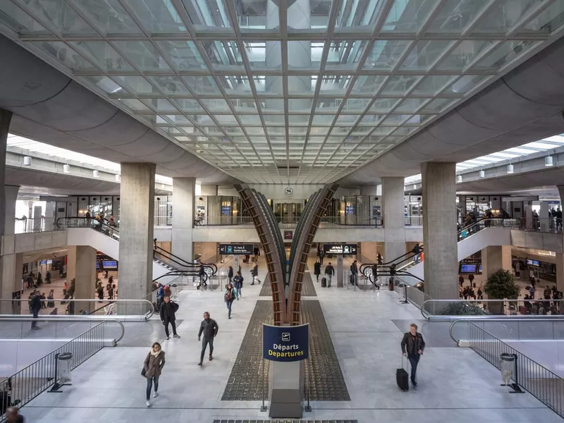 Passengers and travellers passing by a destination board in the departures hall of terminal 2 of CDG Roissy Paris Charles de Gaulle Airport, one of the biggest hubs of Europe